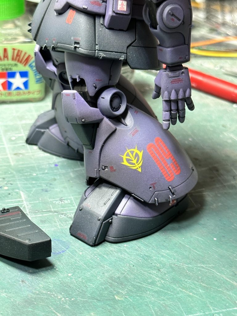 流行り?の脚部機体№マーキングと国籍章。「09」は単に機体ナンバーで、MS-09の09じゃないです。ここだけクリアを厚く吹き、カーモデルのように研ぎ出しをして段差を消してみました。 今回の塗装は、数回の実戦を経たあと、目だった傷もなく程よくヤレた感じ、整備はまだ充分受けられる体制のもと出撃後の洗浄もしっかりなされている、という雰囲気にしようかと(細かい)。そのため、ウェザリングツールによる汚しは行わず薄い塗料を何層も重ねて経年を表現することにしました。チッピングも油汚れも、たいていヤリ過ぎで廃車同然の汚さになっちゃうのが嫌だったので…。実体弾のジャイアントバズもおそらく使い捨てなので、こちらも新品同様パリッとした雰囲気に仕上げてあります。