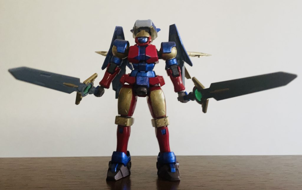 リーオーが素体なのは太ももが大きくがっしりしたフォルムが特撮ヒーローのスーツに近いからであり五年以上前からずっと考えていた特撮ヒーロー風の改造ガンプラに決着つけたかったのが製作背景です最初は光の巨人を参考に赤と銀主体で塗りましたがオリジナリティを考えた結果差し色を金と紫に変更追加装備はジャンク品からコンパクトな装備を選抜かつては持て余してしまった特撮風リーオーですが今回は理想に近い形へと仕上げられて満足しました