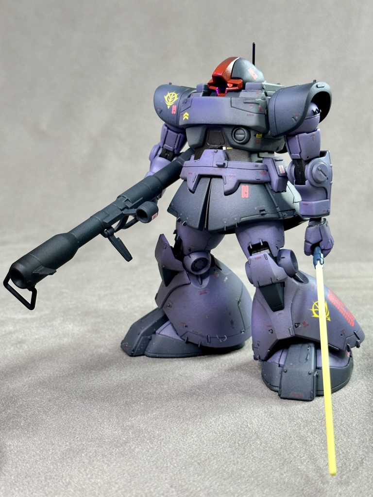 グラナダ工廠で建造された空間戦闘用MS-09Rの初期生産a1型と思われる個体。MS-09R「リックドム」は公式にはワングレードだが、生産時系列順にa1型からa3型、統合整備計画後に生産されたb1型、b2型に細かく分類される。後年、戦場記録に多く残る機体に比べ胸部装甲板が大型で直線基調なところが他モデルとの目立つ相違点。また肩部が複雑な3次曲面装甲を使用していない点も挙げられる。モノアイの直径も小さいが、試作品のワンオフなのか初期型共通の仕様なのかは不明。最初期モデル群は06系のモノアイシステムを流用していたとの説もある。