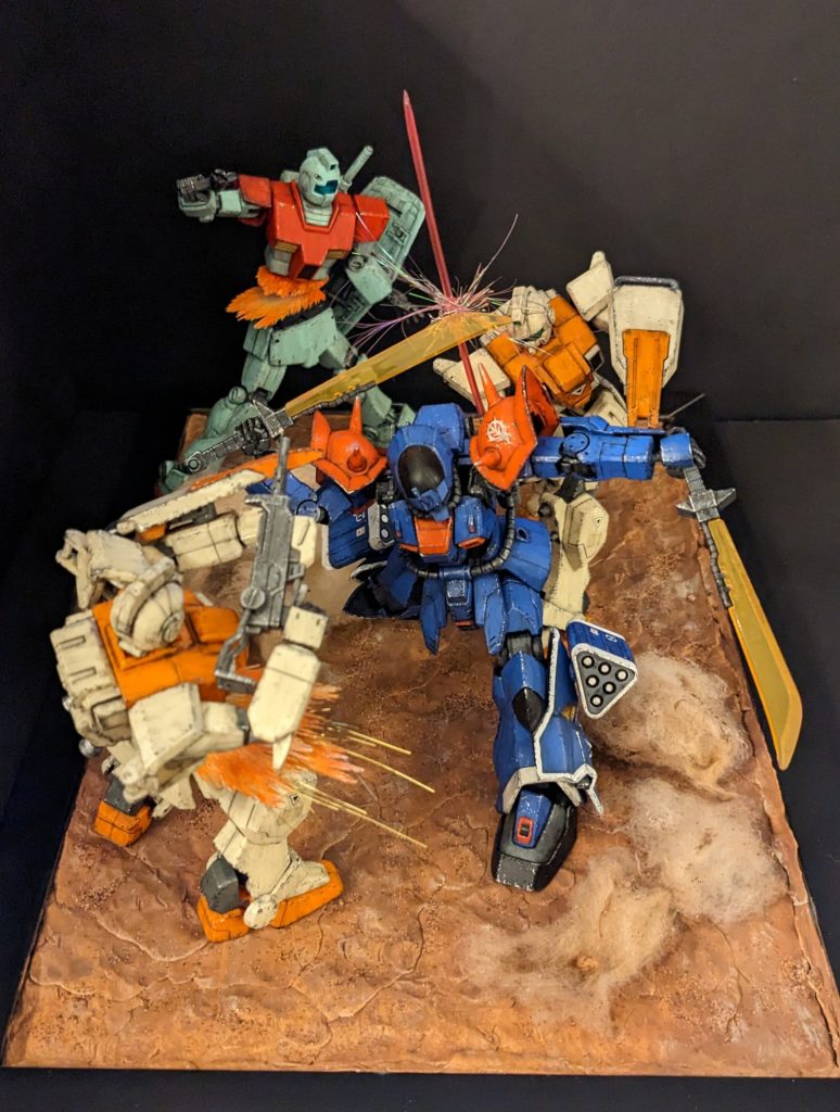 俯瞰図です。まず奥のジムが不意を打たれあえなく両断、手前の陸戦型ジムは射撃前に両断、敵に気付いた右奥の陸戦型ジムは後ろから斬りかかるも、なんとイフリートは二刀を活かした背面ガードで防ぐ!いう感じです。