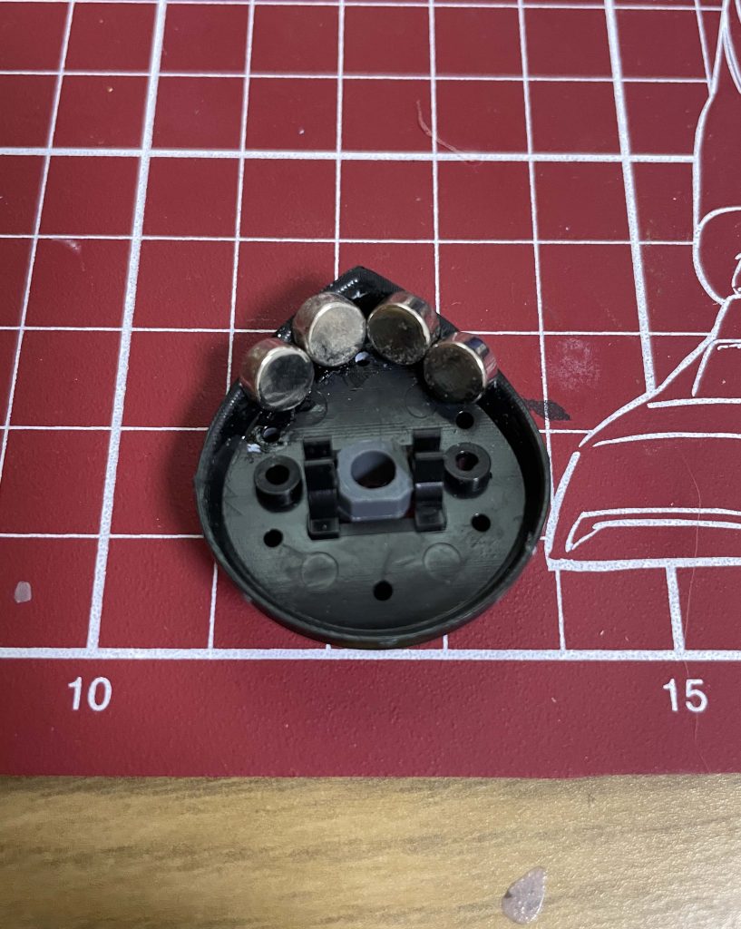 モノアイの裏側。ネット情報を参考に100均のネオジム磁石を接着しています。この磁石で表からモノアイパーツを固定しています。