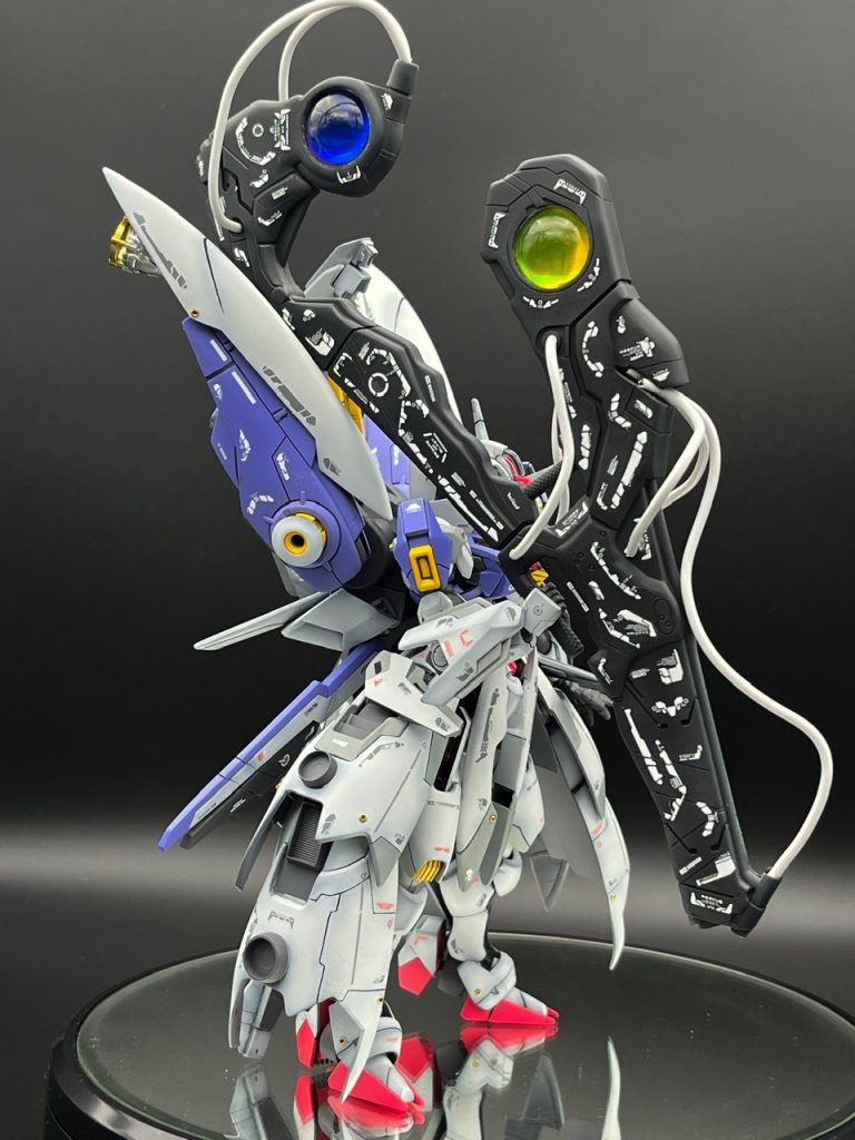 原型は旧きLMエヴァンゲリオンのポジトロンライフルを逆さまにして、紋様っぽくラインデカールをびっしり敷き詰めました。宝玉部分はUVレジン製で、赤緑・青黄と、左右で色を変えています。しかし重すぎてもはや鈍器。チュチュ先輩仕込みの打撃戦も可能です。