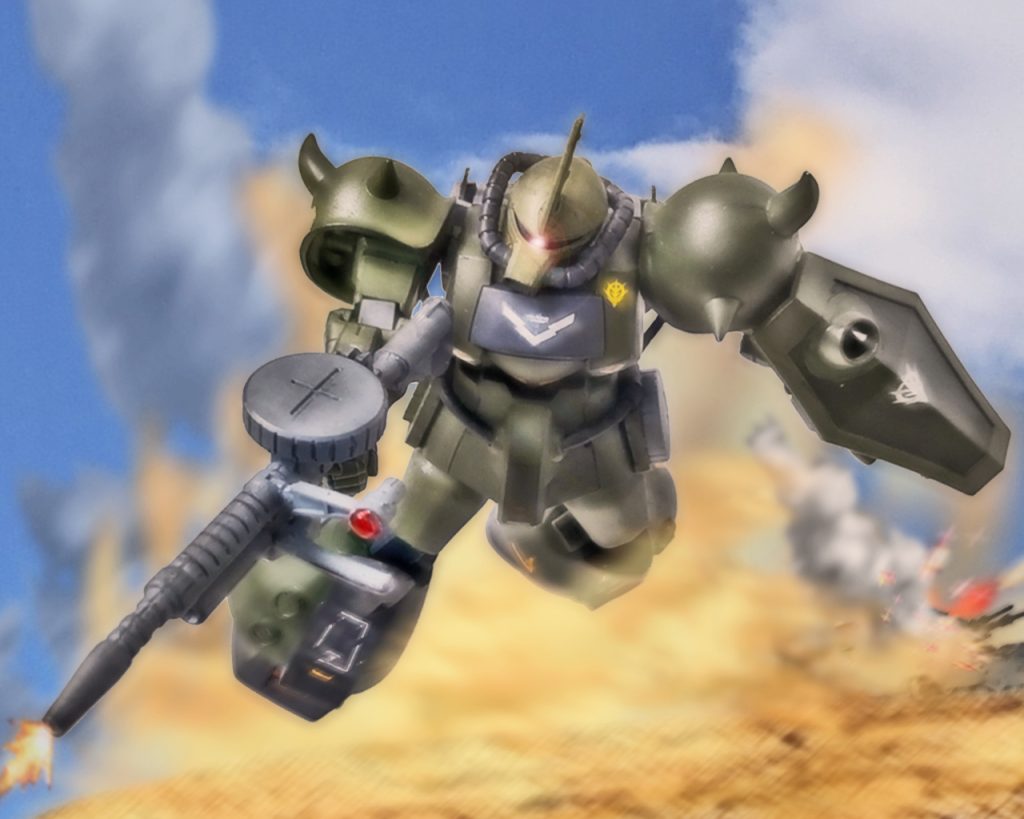 オリバーはグフを再加速させ速度を上げる。直ぐに戦車隊との距離は縮まり、先手必勝と120mmマシンガンを撃つ。至近距離で弾を叩き込まれた61式は数発のみの被弾で大破した。「1つ目!」ヒット・アンド・アウェイで直ぐに次の目標に狙いを定める。「おいっ5番機がやられたぞ!包囲陣形を取れ!」戦車隊は陣形を整えるべく動くがトーチカが荒らした地面に足を取られ素早く動けない。それに対しグフは地面から離れている為、不整地でもその機動力を殺さず駆け抜ける。「2つ目!」数では勝る連邦軍だがここでは1機のMSが主導権を握る。グフは一騎当千ばかりにその性能を見せつける。戦車は各個撃破され炎と煙をあげるとグフが巻き上げた砂塵に飲み込まれていった。