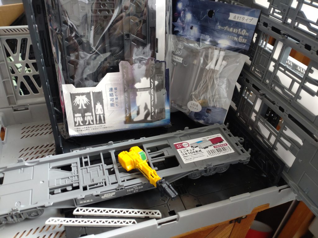 格納庫の素材ですが、背面は山田化学様の「ディスプレイベース」を使用しております。側面ですが、これまた山田化学様の「ミニチュア コキ106形式」を3台、プラ板やプラ棒で接続しています。ミニカーバラした時のクレーンでリフトや、はしご車のハシゴ部分でキャットウォークを作成しました。全体的な塗装は、缶スプレーで行い、墨入れ、ウェザリングを若干しました。