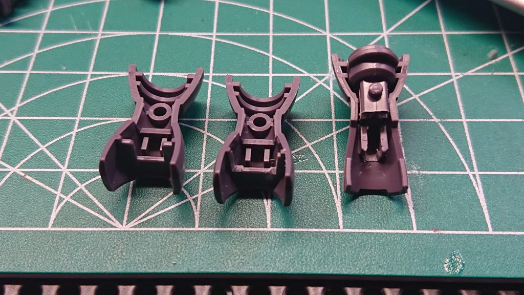 外装パーツの上部(写真では下部)の入口を削ることで合わせ目処理後もフレームを差し込むことが出来るようになる。(写真左が未加工、中央と右が加工済み)