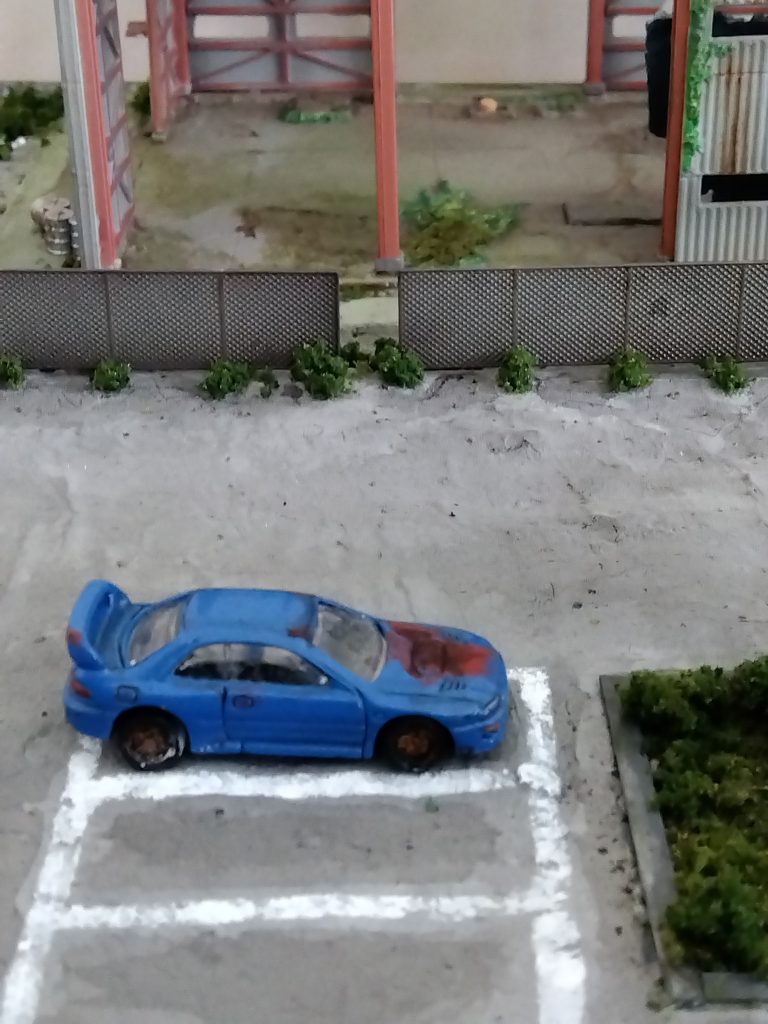 廃車は引越不用品販売店から購入したミニカーにアクリルガッシュで錆を施しました。駐車場の白ラインはマスキングテープの上から叩きつけるように筆塗りして掠れた表現を。