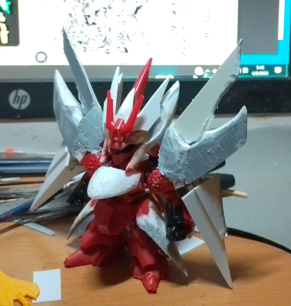 本体はEXSDサザビー製ですが、今回は肩アーマーが小さいためフィルムを直接貼り付けて肩アーマーを大型化しています。頭部側面、胸当て、最上部の刃状パーツの付け根、サイドスカートなどの新規に製作した曲面パーツは、オリジナルパーツにフィルムを貼り付け、エレクトロクロミックでフィルムを溶かして製作しています。鉄。吊り下げ式肩アーマーは原型の肩アーマーに穴を開けて取り付けられており、外側に振り出すことで手首の可動の妨げを軽減します。