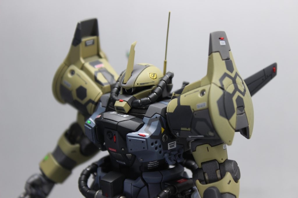 今回はジオラマも出来ていて書くことあまりないので機体の改修に関して細かく書いてみたいと思います。まずは頭部の改修です。ブレードアンテナのエッジをヤスってうすうす攻撃、真鍮線と真鍮パイプでアンテナを作成しました。モノアイはバイザーにしてしまったりが多かったんですが、ハンドパーツ(後述)のおまけでモノアイとモノアイレールのセットをいただいたので、ほぼ初のモノアイに挑戦してみました。レールとモノアイは色味の違うシルバー系で塗装し、モノアイの内側はクリアブルーで塗装、はみ出て失敗したところがうまく隠れるように接着しました。ただ、あんまり見えないですね…笑胸部はエッジ出しをして、正面には追加装甲、側面にはブチ穴を開けていくのが最近の常套手段になってます。肩には初めてエッチングパーツを入れてみました。ダボの関係で穴を貫通させたくない時なんかに便利だと思いました。