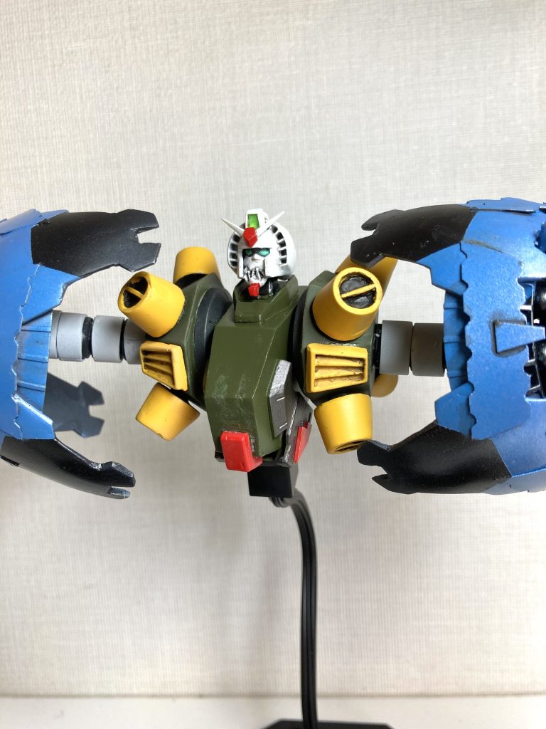 頭部は、1/144HGガンダムをベースに2㎜巾のプラ板を貼り付けてインテーク部分を作り、その上に0.1㎜のプラペーパーを貼り、さらにエポパテを盛って頭部全体の丸みを出しました。フェイス部分は上下に分割し、プラ板の切れ端で牙を生やしました。ボディ部分はプラ板工作です。胸のインテークは旧キット1/100ガンダムmk-Ⅱのパーツの複製です。