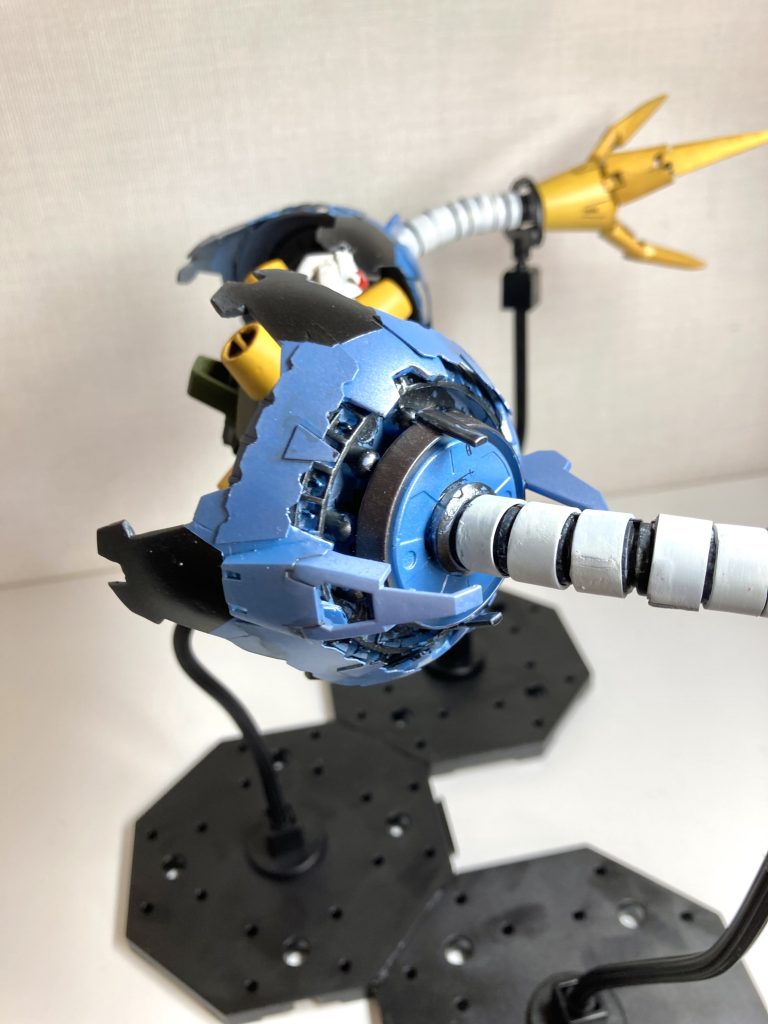 両腕の丸いカバー部分は、さるプラモデラーの方の作例を真似して、HGUCギャン の盾を芯に、プラ板やジャンクパーツを貼って拵えています。腕部分は、ホームセンターで売っているコルゲートチューブ(電気配線などをまとめるチューブ)を軸に、短冊状に切り出した0.3㎜プラ板を巻き付けてバイブ状にしました。