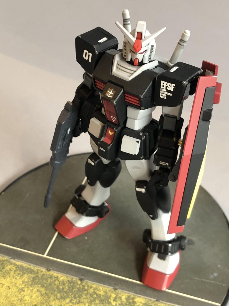 EGガンダムは肩アーマーが薄くて心許ないのでプラ板を貼って厚みを出しておきました。定番ですがアンテナのバンダイフラッグはカットしてあります。1号機のカラーリングは「ロールアウトカラー」とされていて、いずれ2号機と同じくトリコロールカラー（祝典用？）に塗り替えられる予定であったという説があるそうで、旧キットのインストになっている別カラーがそれであったようです。で、この「ロールアウトカラー」のライトグレーは実は地金の色、すなわちシルバーであるという解釈もあるようなのですが、そうすると顔面もシルバーなわけで、それはちょっとどうなのか？とも思うので私は設定通りライトグレーを推します。