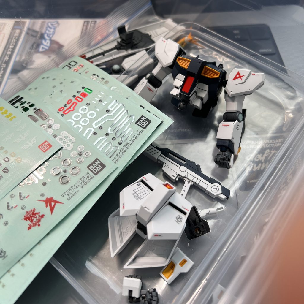 leftover hand parts and stickers from RG Nu Gundam and Unicorn Gundam.