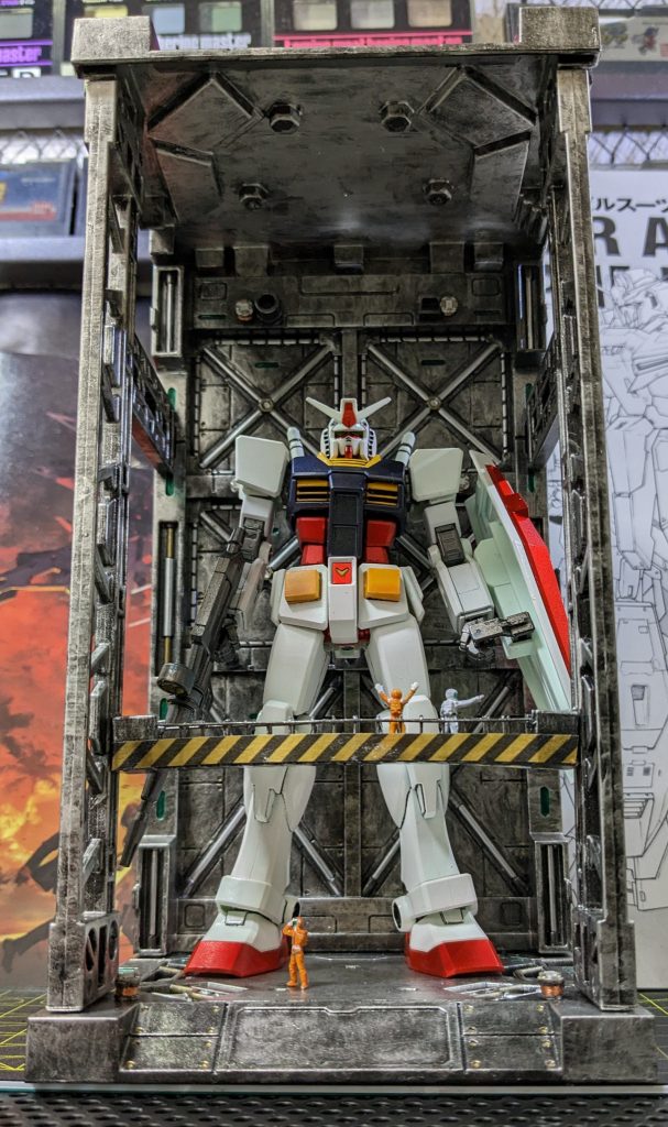 頑張ってビルダーズパーツのフィギュアになんとか着色。ワンポイントで手すりの下部にコトブキヤのコーションマスキングテープBを貼りました。これけっこう使い勝手良いのに今は手に入らないんですよね。再販希望！（紅白のは売ってますが使うなら断然黄黒でしょ。）ベース部分はガンメタ塗装の上にガンダムメタリックマーカーで部分塗装。最後に全体にシルバーでドライブラシかけてます。