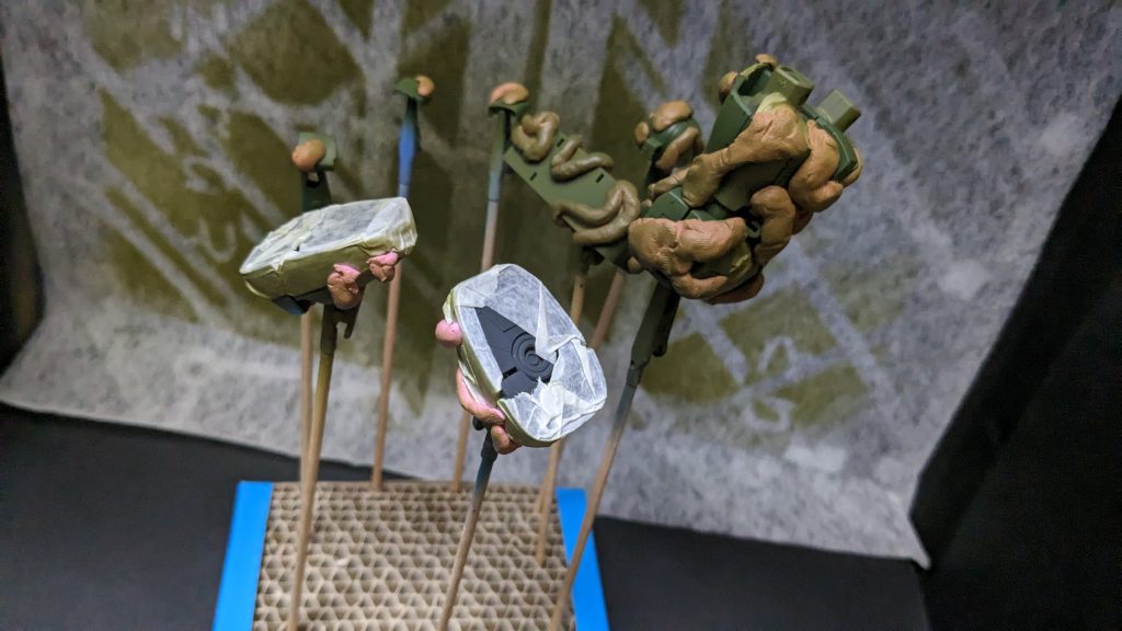 1回目 迷彩パターンにくり抜いたマスキングテープに伸ばした練り消しとコツコツ貼り付けてから下地塗装よりも明るい色で吹きます