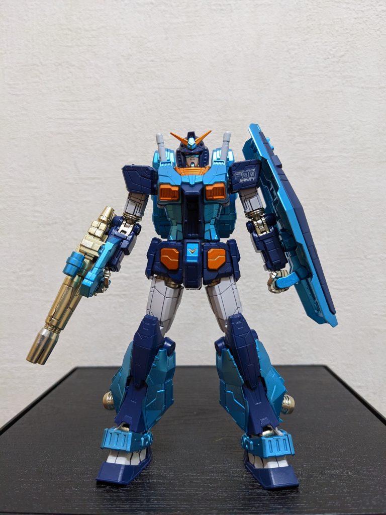 完成体前面肩のマーキングシールは、片側だけの方がアクセントになると思い、左だけにしときました。肩と膝のキラキラシール(実物の横浜ガンダムで発光する箇所)は、何となく合わない感じがしたので省略😅今回のカラーアレンジ、個人的にキットのデフォのままだと「黒と濃紺の色味が近すぎてメリハリに欠ける❓」「フル装備状態で白の箇所多すぎ」「赤要らないかも」と感じたので、「黒・赤・濃紺」→「濃紺・青」に変更したのが主な変更点です。赤をオミットすると言っても、単に「地味にしたい」ワケでは無いので、アクセントとしてオレンジを散りばめました。結果、またもや「成型色の白がワンポイントに」なっちまいましたが・・・😅あと、「70年代スーパロボット風」に「脚回りを重厚な感じにする」のも狙いました😆結果、「右腕のツイン砲+ドッシリ脚」で、色味は違えどパーフェクトガンダムみたいになりましたね😳