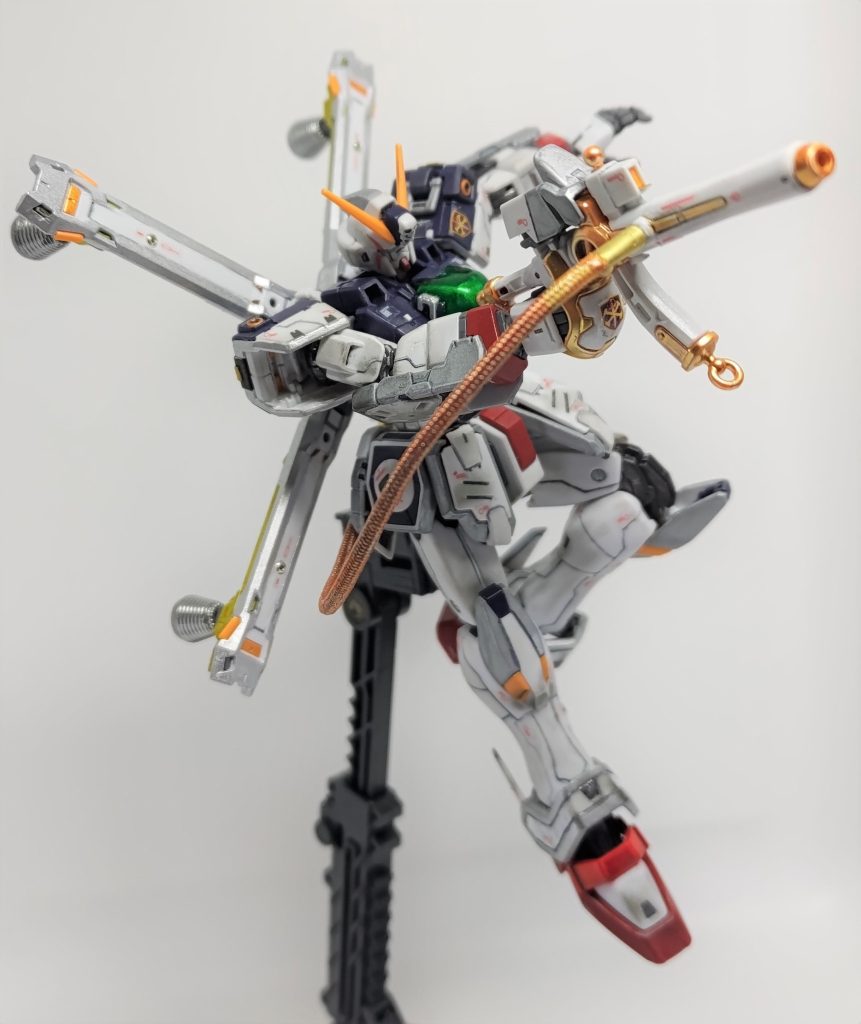 ここからは脳内設定を含めた改造です。サテライトシステム対応と言ってもD.O.M.E.は無い、リフレクターが小さいので戦略級兵器ほどのエネルギーは受け取れない、また小型・軽量・高出力というクロスボーンガンダムのコンセプトに反するのでは、などと考えた結果、サテライトキャノンは装備していません。本機のサテライトシステムはサナリィが試作したオプション装備で、母艦であるマザーバンガードとの連携を前提とし、母艦からのマイクロウェーブ照射を受けて機体にエネルギーを充填することで、一時的に出力を底上げしたり継戦能力を高めるものという設定です。機体背面からザンバスターにつながるエネルギーチューブは、マイクロウェーブを受けたリフレクターからザンバスターにエネルギーを直接供給し、高出力のビームを撃ちだせるようにしようと追加しました。ハイキューパーツのメッシュワイヤー(ホワイト)の両端に真鍮パイプを接着して、ガンダムマーカーのイエローゴールドを染み込ませるように塗っています。パイプの先を少し狭め、コアファイターのアクションベース接続部の内径、バスターガン側面のボス外径に合わせました。・・・でもこれだけなら、まだエネルギーにもパワーにも余裕ありそうだなってことで・・・