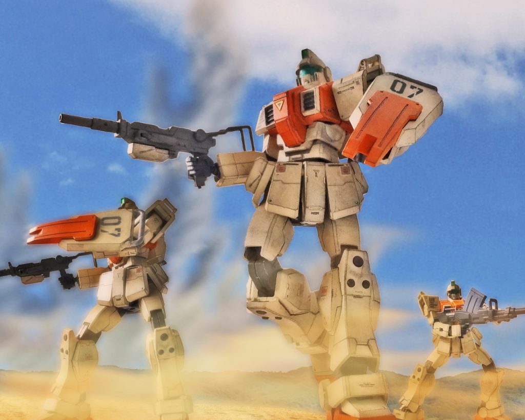 「おいおい、こんな作戦立てたのは何処のクソ野郎だ!」ロブは陸戦型ジムのコクピット内で悪態をつきながら戦車隊がやられていく様を見ていた。「ありゃジオンの新型か?見たことねぇ」同じ小隊のマイクもMSの足を止める。今回の作戦は撤退中の小規模な後方基地を制圧するもので、戦力は少ないと聞いていた。だがMSの配備は予想されていた為、数で一気に制圧しようと戦車一個中隊を投入したがこの有様だ。「7小隊聞こえるか?!」ロブのもとに戦車隊の指揮官から通信が入る。「おう、派手にやられてるじゃねぇか。ザクなんか目じゃねえって吠えてたのは何処の犬だ?」「五月蝿いっ!貴様らの出番だっ!さっさと前に来い!」「へっ、よく吠える犬だぜ。マイク、サリー、前進だ。奴ら露払いにもならなかったな」「了解!」「聞いていたな8小隊のトラック。つー訳だからアシストよろしく」