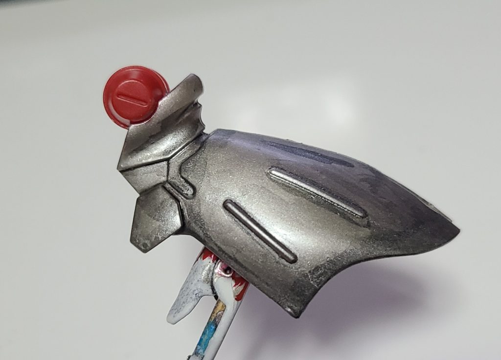 塗装の順番として下地のチタンシルバー→チタンシルバーとフラットブラックを調色し、モールド部分やトーンダウンを行いたい所へ陰影塗装→かなり薄めたチタンシルバーで光沢面の調整(画像はこの段階です)→メタリックレッドを２度塗りを行っています。フィニッシュは光沢です。原理的にはグラキャンディと同じですが、下地と陰影が逆になります。これにより、光量によってモールドの発色が変わってきます。