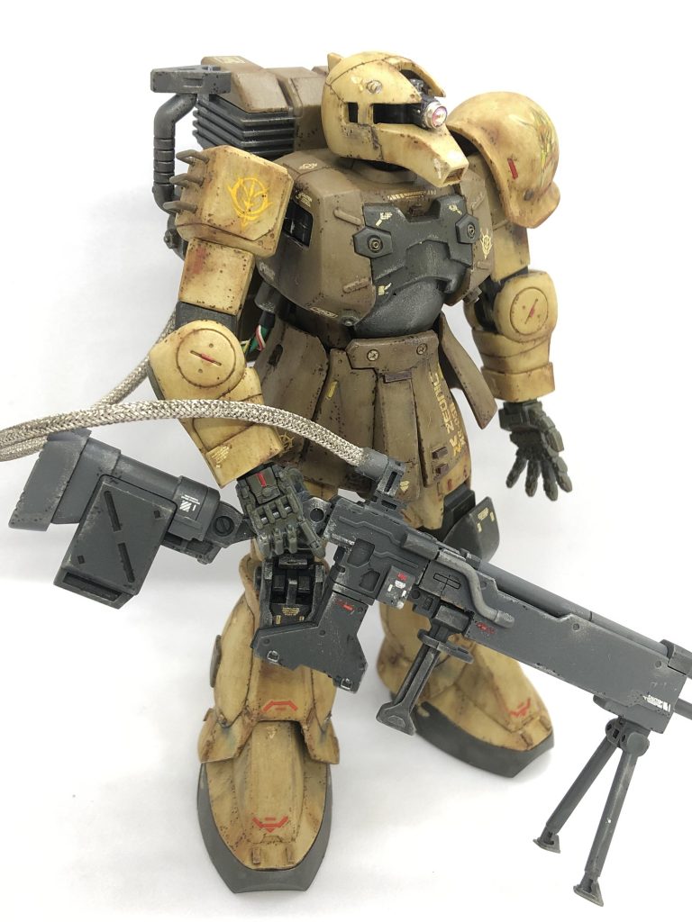 左側面から。 この写真で見ると分かりやすいのですが、モノアイをメタルパーツにしたら想像よりも頭部から飛び出してしまいました。スナイパーとして高性能モノアイを使用しているという設定で一つ。 実は右手の保持力が低く(武器の重さで指が外れてしまう)、スナイパーライフルを持たせた状態で接着したのでかなりポーズに制限が掛かっています。