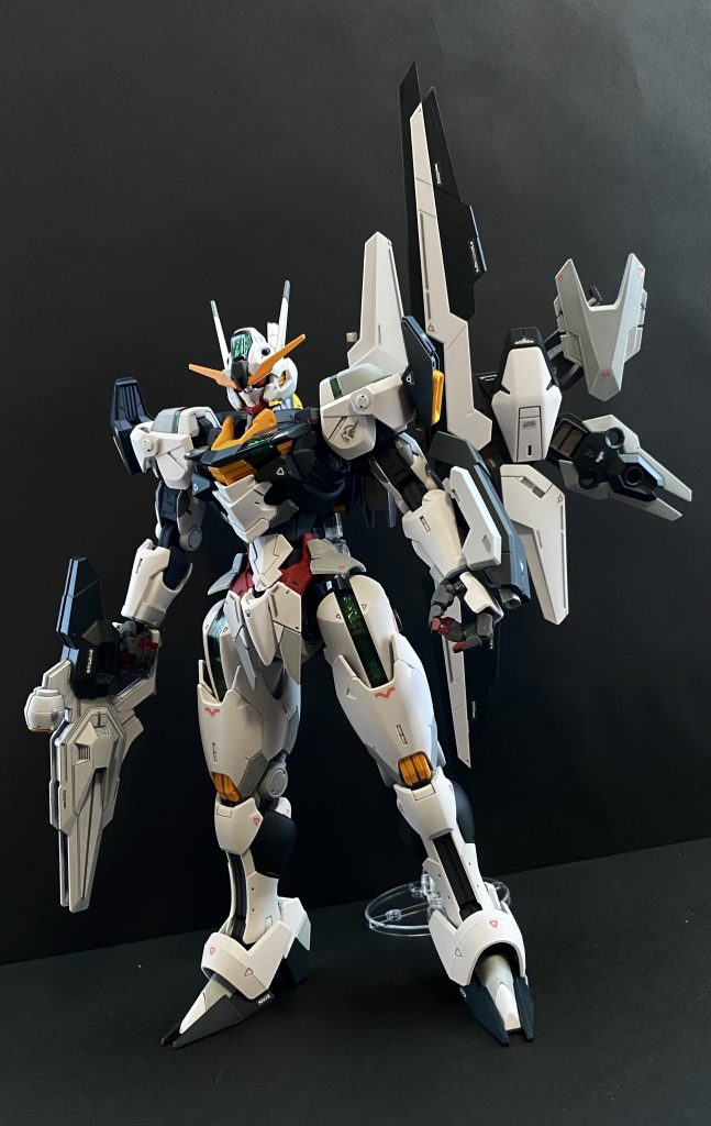 ガンダムエアリアル 改修型 中破したエアリアルを、最終決戦に向け、シン・セー開発公社のサポート、学園内の複数の寮のメカニック科の生徒達の手により復元、改修された機体。その最大の特徴は、機体背部に装着されたエスカッシャン、ガンビットであろう。生徒達により主にジャンクパーツで組み上げられた。専用の基部ユニットにガンビットを個別に接続することで、ガンビットを「一つ」づつ展開することが可能となり、エネルギー効率の向上が見込まれる。(従来は、シールドとしてまとまっているか、全てのパーツが展開しているか、だったがこの基部ユニットに担架することで、三つだけ展開するなどといったことが可能となっている)また、装着されたガンビットの配置を変更することで、高機動(ダッシュ)モードになることができる。