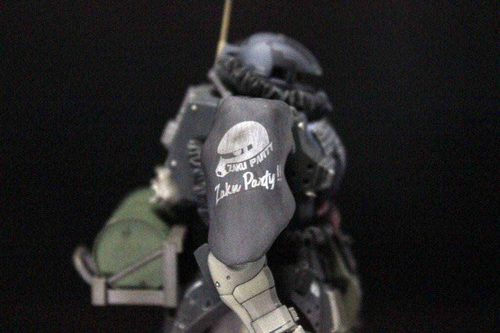 現地改修その6、防塵カバーです。なんかそれっぽいことを言っていますが、以前行った八王子の展示会でエポパテでマントを自作している方がいたのをパテが余ったタイミングで思い出し、半乾きくらいの時に肩のパーツに合わせて整形しました。ザクパーに参加した時のお土産デカールがお気に入りです。