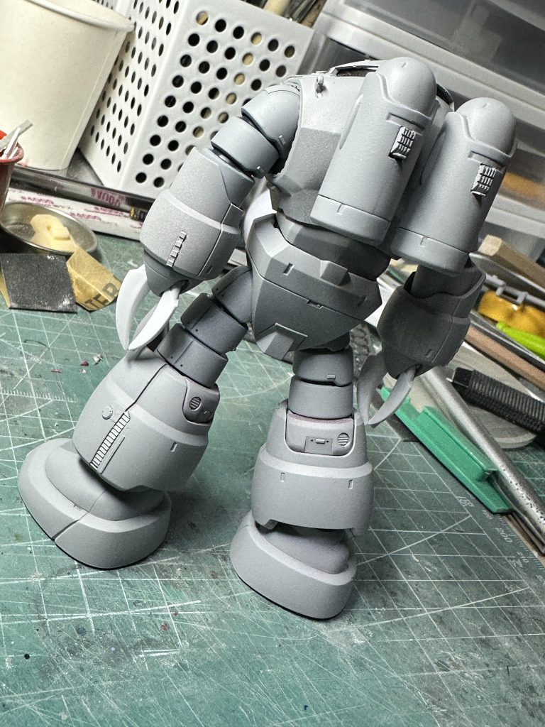 おなじくサフ状態の後ろ姿。お気に入りは膝裏の円形スリットモールド。社外品のディテールパーツですが、ピンバイスで穴を開けて奥に仕込む感じで立体感を増してあります。見えにくいですが、肩口にはぐるりと凹凸モールドで縁取りして、肉厚感を出しました。