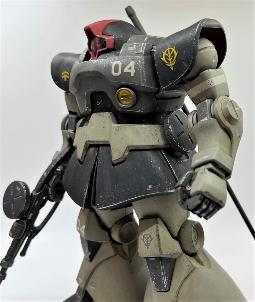 ウェザリングは前回制作したサムズアップ旧ザクと同じ手法を採用しました。クレオスウェザリングカラーのグランドブラウンで強めの茶色でウォッシング＆スミ入れ→サンディウォッシュで砂汚れ付加→ドライブラシでエッジ強調＆金属色アクセント→チッピングで情報量UPです。数百円の塗料数種と綿棒、捨てるレベルの筆でこのレベルの汚しなら手軽に出来てしまうので、良い時代に生まれてきたなと思います。今回、蒸し暑い夜中の屋外でトップコートを吹いたら盛大に白被りしてしまったので、誤魔化す為にかなり強めに汚しました。トップコートは絶対に焦らず、万全の環境が整ったタイミングで吹くものだと再認識した次第です。とても手が回らないくらいのキットを積んでるんだから機が熟すまで他のキットをいじっていれば良いものを、完成が近いとついそのキットばっかり触りたくなっちゃうんですよね(苦笑)プラモは良い精神鍛錬になると思います。