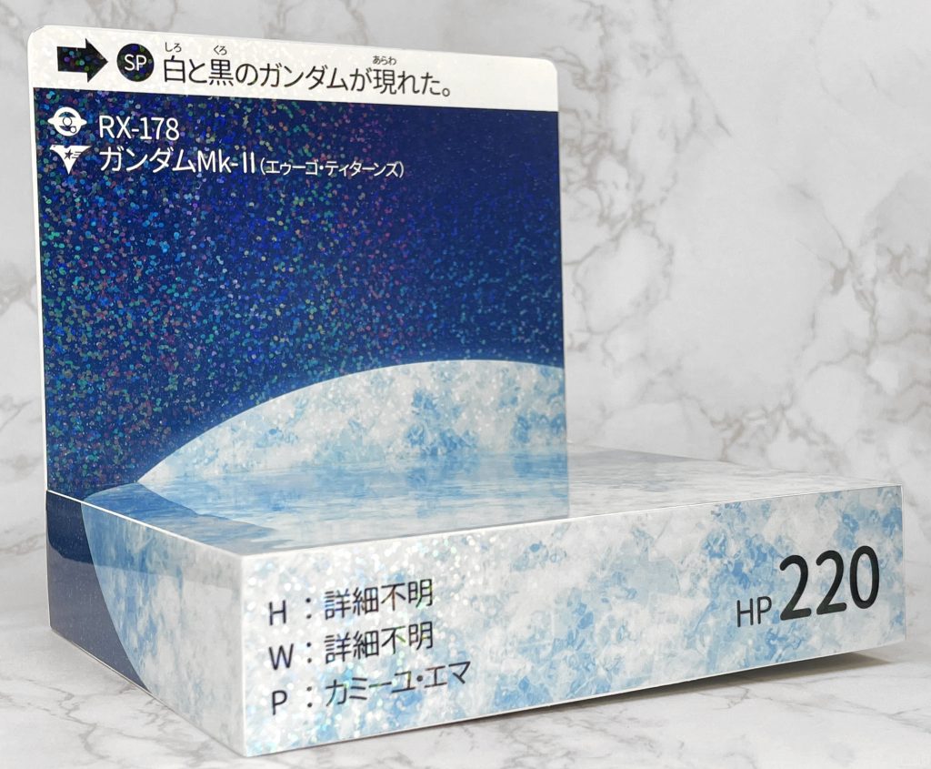 Photoshopでサクッとデザインを作った後プリンター用ステッカーシールに印刷を行い、セリアのホロシートを貼り付けています。セリアのホロシートは画像の他にキラ風のホロシートもあるんですが背景が宇宙なのもあり、聖騎兵物語のさらばガンレックスのカードようなプリズムのシートにしました。星の輝きのようになっていい感じになったと思います。