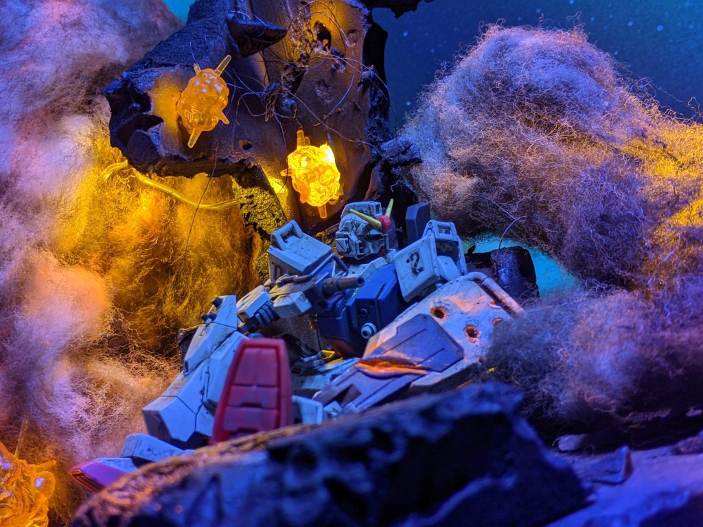 100均の明るさ調整出来るライトとＵＶライトを使用。煙は蛍光オレンジとウェザリングカラーで汚しで作成。ジオラマ本体も百均のスチロール板で制作。こちらはＵＶと百均ライトver.