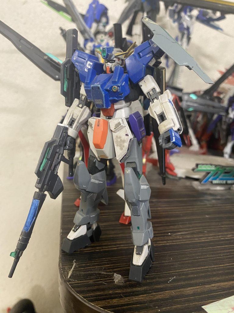 GN-R5 Gundam Lyra Lyra was built in secret. It is revealed to be a secondary sniper unit. It's armaments are the gn sniper carbide ×2, gn shield, and gn beam sabers. Additional thrusters are mounted on the legs for mobility. GN beam saber emitters are also installed in the arms