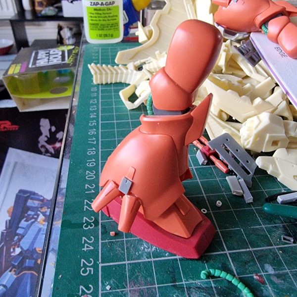 I want to realise the RX-107 Rosette from Advznce of Z in 1/144 scale. The base is HGUC kit. Here is the progress so far. I use AOZ Vol 4 for referance photo's as well as online sources.I began with the head, using parts from other AOZ kit's and brass rod. I used Dspiae plasicard to change shape of torso, and 3D printed the vents. The shield is magnetic so the amount back is held in place.Lots more work to do! （2枚目）