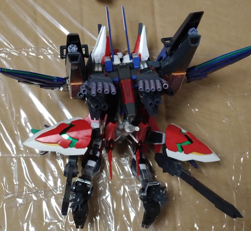 「大部隊を殲滅する為の形態『テンペストリベロ』。ELS相手にどこまでやれるか……」 X(クロス)はこの形態のテストも兼ねて、前線に自ら出たようだ。次々と近づいてくるELSに、リベロはいよいよ戦闘開始。あらゆる火器が次々とELSに直撃する。レギルスシールドを展開し、大量のビットを放出させて攻撃する戦いも見せた。 「侵食していなければ問題ない」 そう言って、X(クロス)はフルバーストによる一斉射撃を連続で行なった。しばらくして、ELSは全滅。と、同時にトラベラーズが安全地帯まで移動した連絡が入る。 「了解した、帰投する」『それにしても、まさかこんなとこにもコピーズが現れるとはな?』「何者かがELSのコピーズを我々に寄越したのだろう。我々が時空を移動していることを知っている何者かが…」『知っているのは、ウチらの協力してる『G:ユニバース』だけだぜ?…まさか!』「いや、仮にそうだとしても自分達が裏切っている痕跡や疑問を残さないはずだ」『確かに…そうだな』 X(クロス)とキュリアがそう話している頃、戦闘に出なかったニノは暗い顔をしていた…。 (私、何もしなかった…。出撃しても、きっと皆さんの足手まといになってたかもしれない) 戦いを見て、自分にできることがないと感じてしまうニノ。そんな彼女の隣で、従姉妹のカナはあることを考えていた。果たして、カナは何を考えていたのだろうかーーー 『機動時空転移 ガンダムリベロ 第5話:時空の狭間での戦闘』 今回のストーリーはここまで。続きは次回のお楽しみ。 ストーリーの会話で『G:ユニバース』の言葉が出ましたが、実はクロストラベラーはゲームの『バトルアライアンス』に登場するキャラ達と繋がっているという設定になっており、X(クロス)達がマルチバースでコピーズを倒した後に彼らが裏でそれぞれの歴史を修正している……という流れです。もしかすると、『バトルアライアンス』のガンプラも作って投稿することがあるかもしれません。その時は是非とも宜しくお願いします。