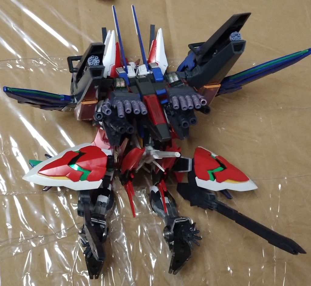 武装は『多種装備ハンドガン』、『テイルビームライフル』、『GNソードライフル』、『ミサイルポット』、『GNキャノン』、『ガトリング砲』、装着により使える『ロングライフル』とビット攻撃の為の『レギルスシールド』、更にはその形態での足の向きを変えてネクサスの腕のハンドから発射できる『パルマフィオキーナ』。これらによるフルバーストによっての一斉射撃も可能。