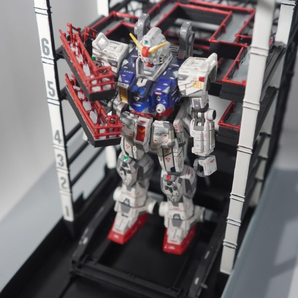 横浜ガンダムのドック(1/144)を作成中。最終目標は見学棟をフルスクラッチすることなので、まだ未完成ですがある程度形になったのでいったん公開します。台座前面の文字(GUNDAM-DOCK)以外のシールは使わず、1,2列目の柱を白色に。(3列目は塗るのが難しいので断念)歩道ももとは黒一色でしたが、赤色に塗ったプラ棒(1mm)をつけ、床を塗りました。稼働するほど部分はプラ板でスクラッチしています。 （2枚目）