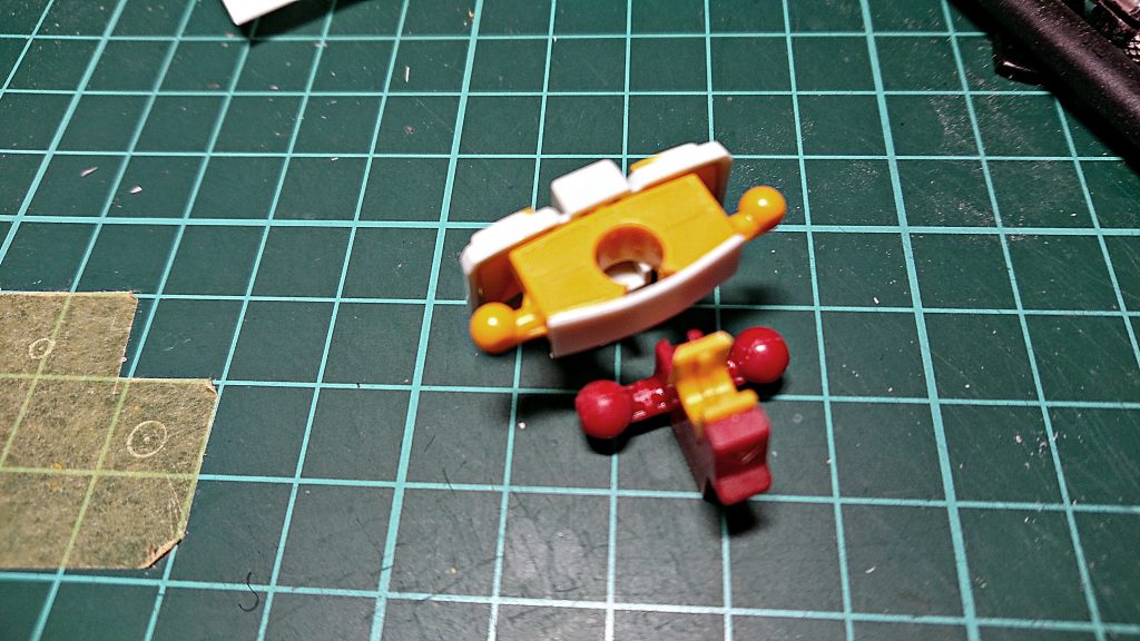 腰フレーム部分工作の一枚・黄色いフレームを画像の部分でカットして、プラ板積層で厚さを調整後に、赤いパーツを接着 調整した厚み分で、腰部前側の装甲を動かせるスペースを作ったことで股関節の角度がつけやすくなりました