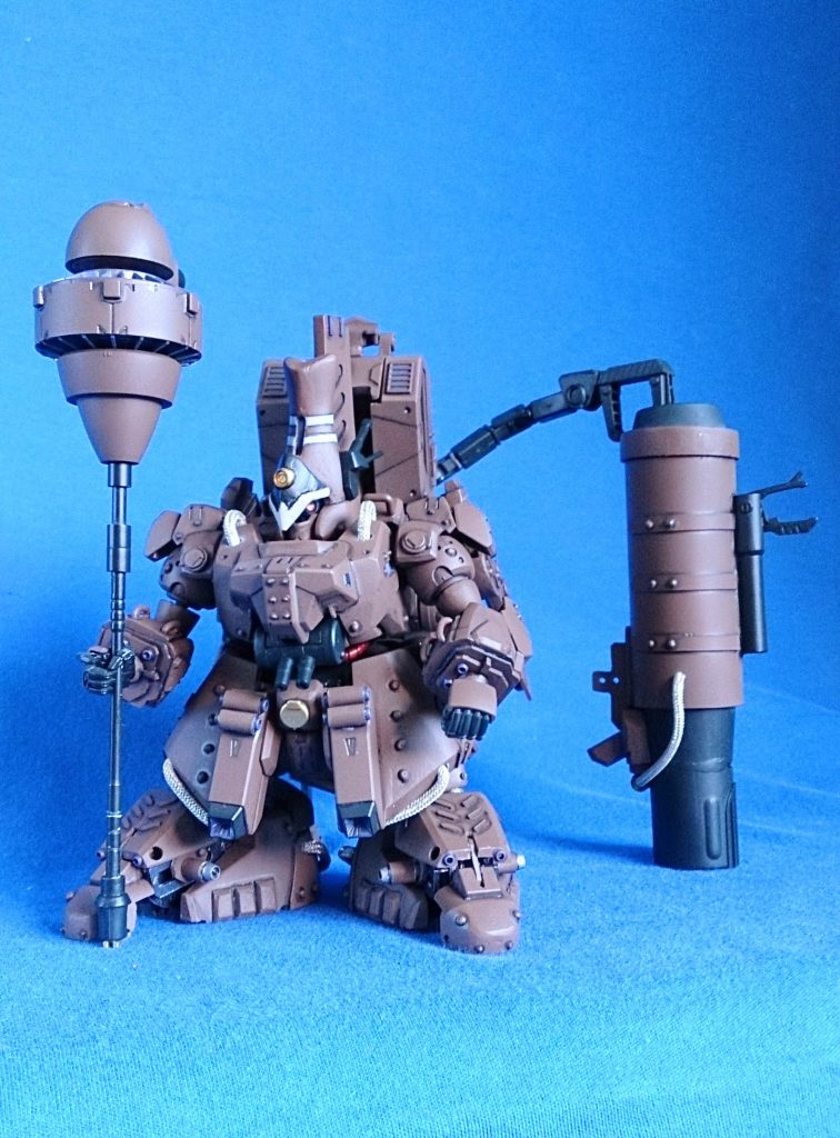 バックパックユニットには隠し腕を搭載。腹部に二連機関砲。要塞攻略戦を得意としており、巨砲から繰り出される一撃は、敵基地の防御を易々と粉砕する。