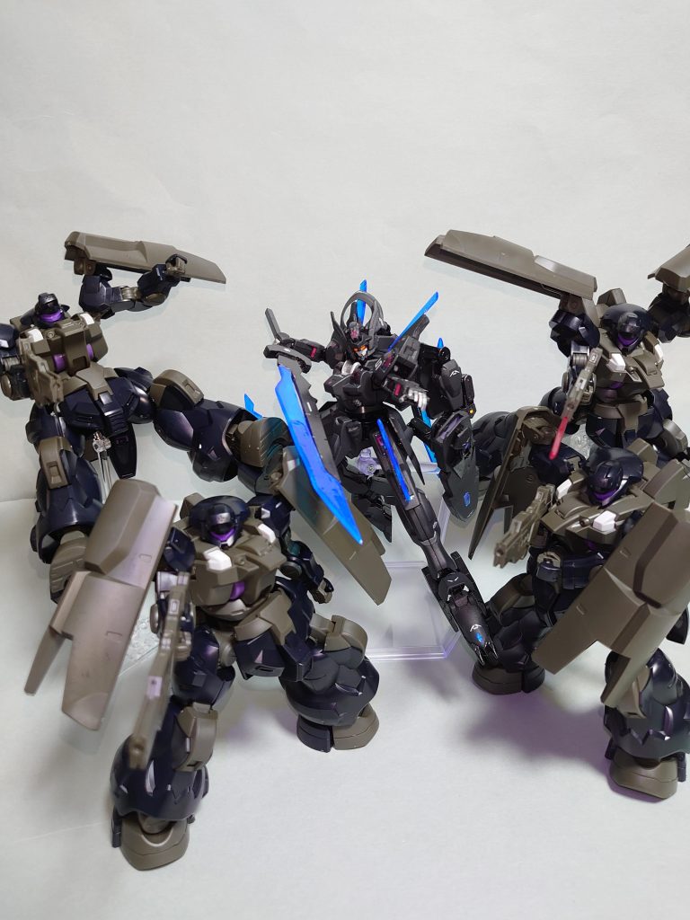 MDX-0005 ガンダム・シュヴェルジッツジェターク社のAI研究部門がダリルバルデをベースに一時的に接収していたガンダム・エアリアルのデータを活用して開発した第５世代MS。機体の中枢にはシュヴェルバルデから移植された意志拡張AI「SUSANO-O」が搭載されている。ガンダムの名を関した機体だが本機の操縦インターフェイスは従来のGUND-ARMとは異なり、機体とパイロットとの接続の間にAIを挟む形式を取っている。その際、AI側がデータストームの負荷を負担することで人体への悪影響を抑え込むことに成功している。しかしGUNDフォーマットとの間にAIを挟むことによって機体の挙動にタイムラグが生じるため、反応速度では純粋なGUND-ARMには劣る。ただし、AIとパイロットとの同調率によってはこのタイムラグを限りなく軽減することが理論上は可能とされている。ジェターク社本社にて起動実験が行われた後、先行してロールアウトしたガンダム・シュバルゼッテのパーツを流用することで実戦配備型として完成したのが本機である。その為、コックピットブロックを除いて外装の大半がシュバルゼッテに置き換えられている。基本装備はシュバルゼッテの内装火器に加え、強化型イーシュヴァラ「マへ―シュヴァラ」と主武装である多目的攻防プラットフォーム「ハバキリ」を備えている。手持ちの刀剣に加え、サブアームと全身のレーザーブレードを併用することで高い近接格闘能力を有している。本機はクワイエット・ゼロ事件を巡る最後の戦いに置いて議会連合の介入に対する抑止力としてオルトリンデ隊に緊急配備された。同部隊に派遣中のムラクモの乗機として一連の事件の後方で議会連合の派遣したガンダム・ルブリス部隊と交戦、複数のルブリスタイプとガンヴォルヴァを撃退し、べネリットグループの本社フロントを守り抜いた。シュヴェルジッツとはドイツ語で剣を意味するシュヴェールトと居場所を意味するヴォーンジッツからの造語であり、【剣の居場所】という意味を持つ。そこには自身の居場所を得るために戦い続けてきたムラクモが見つけた彼の居場所であるジェターク寮およびジェターク社を守るために最後まで戦い抜くという決意が込められている。「守りたいものがあるから。戦う理由なんて、最初からわかっていたんだ。守って見せる・・ここはようやく見つけた、僕たちの居場所なんだ」・ムラクモ・Mジェターク寮に所属するパイロット科３年。学籍番号KP017。剣の腕を買われてジェターク社にテストパイロットとして拾われたアーシアン。現在はジェターク社管轄のセキュリティフォースの部隊、オルトリンデ隊に派遣されている。コールサインはオルトリンデ５。意志拡張AI「SUSANO-O」開発のために地上での戦闘に参加していた。自身の居場所を得るために戦い続けてきた彼は、自身が生きる為に地上で同じアーシアンに刃を振るい続けることに対し、そうまでして自分が生きる為に戦う意味を見出せずにいた。そんな中で、上官からの「自分たちはただ求められた結果を出すしかない」という言葉で心を保ち、ジェターク社の為に最前線で鬼神のごとく活躍をした。その後はテロによって被害を受けたアスティカシアへの救援の為、学園へと戻り、傷ついた後輩たちを励ます中で、彼もまた自分の守るべき存在に気づく。自分を受け入れてくれたジェターク社、ジェターク寮という居場所と仲間たち。守るべき自身の本当の居場所を得た彼は動乱の中で最後までそれを守るために戦い抜くことを決意する。そして、クワイエット・ゼロを巡る最終決戦では議会連合の介入に対する抑止力としてガンダム・シュヴェルジッツを受領し、グエルやフェルシー達の帰る場所を守るべく戦い抜いた。・意志拡張AI「SUSANO-O」ジェターク社のAI研究部門が開発した試作型意志拡張AIの一つ。シュヴェルバルデから本機へと移植され、メインOSとGUNDフォーマットの制御を担う。SUSANO-Oは駆動系制御と空力制御を得意とする傾向があり、学園での決闘から実戦得て共に戦い続けてきたムラクモとの同調律が非常に高い。その為、シュヴェルジッツの欠点である操縦系のタイムラグを限りなく０に近づけることが可能となっている。これまでも搭乗者の意志や感情を理解しているかのような挙動を取ることがあったが、クワイエット・ゼロを巡る最終決戦の中では多大なデータストームの影響を受けたことでAIでありながら完全な自我を持つようになる。その際、パーメットを介して意思疎通を取ることが可能となり、意志拡張AIとしての一つの完全体へと進化を遂げた。最終決戦では覚醒したその能力を活かし、パイロットと共に機体性能を限界まで引き出し、ガンダム・ルブリス部隊から本社フロントを守り抜くことに成功する。クワイエット・ゼロ事件後は、その存在の危険性を危惧して開発計画から抹消、ムラクモの乗機に引き続き搭載され、前線で運用されることとなる。