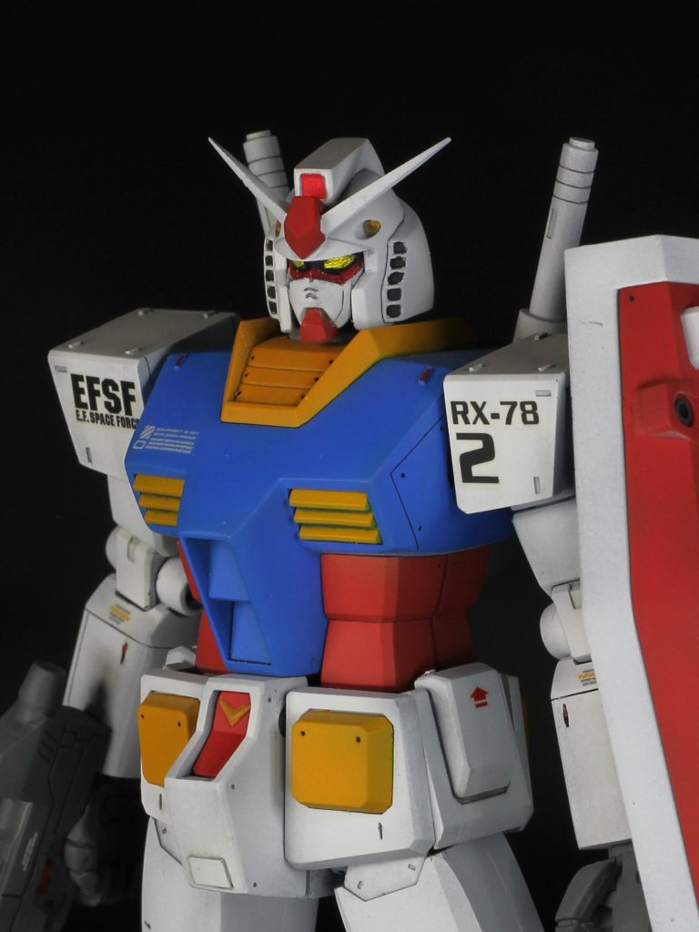 胸や肩のように、本体を守る鎧としての機能が重視される部分は、正面にパネルラインを入れないようにしています。その代わり側面に入れました。デカールにおいては、「ガンプラのコーションマークでかすぎ問題」に僕なりに向き合い、でかくてもおかしくないと思ったものだけを選んで貼りました(「可動部の衝突に注意」とか、「熱いよ」とか)。矢印は合体ギミックを表しているつもりです(サーベルラックにも貼りました)。