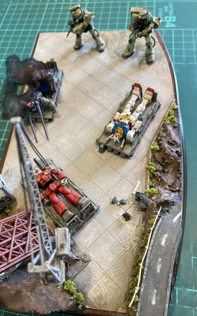 ザクは、左肩のシールドを切り離し、背中側に再接続しました。そのほか、首の角度などポーズを変更しています。100均のプラケースに収まるよう、土台の前面も少しカーブさせています。