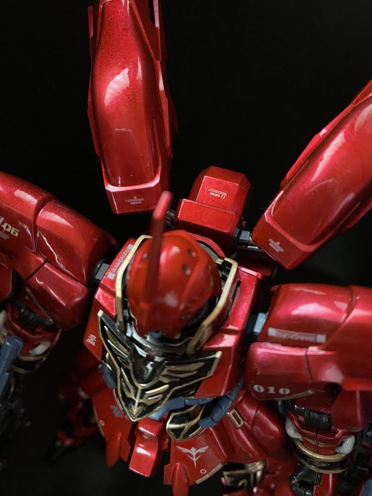 この作品のもっとも力を入れたポイントが、赤い装甲部分のキャンディ塗装です。黒下地→シルバー→クリアーレッド二層→(この段階で赤が十分発色してきたが、深みだしのため)薄めのクリアーレッド一層→デカールと筆塗り部分塗装→光沢クリアートップコート。完全乾燥後、パーツを一通りクロス研磨。水性ホビーカラーエアブラシ塗装でリンゴ飴状態を目指しました。指紋が怖くてゴム手無しでは触れませんが、バイクのボディのような曲面が美しく光ります。