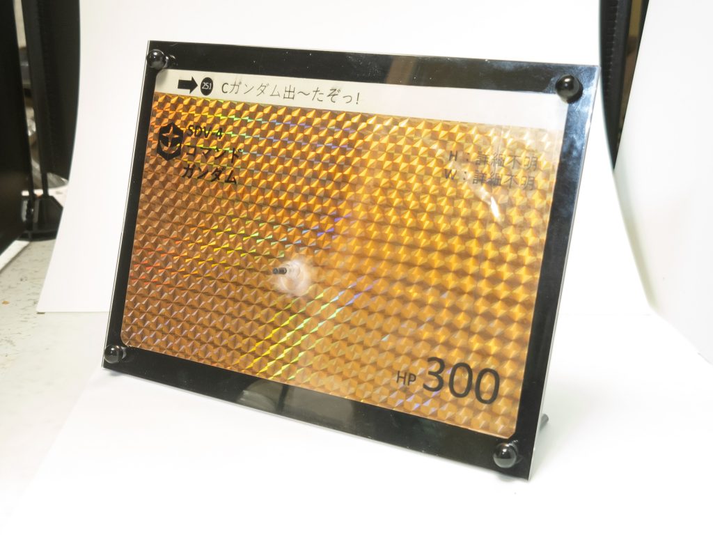 台座は100均のフォトフレーム、OHPフィルム、折り紙で制作しています。接続はキットのバックパックにナイフをマウントするダボ穴で行います。