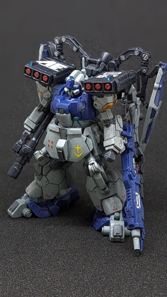 型式番号:MS-09［GD］機体名:G-DOM武装:ハイパーバズーカ、肩部ミサイルランチャー、ビームサーベル、プロトメガランチャー特徴:U.C.0084年5月地球連邦軍のジオン残党狩り部隊「ヒッツェシュライアー」はジオン残党軍の遊撃部隊と戦闘。その時鹵獲したドムフュンフの損害が奇跡的にコックピットブロックのみだったため軍の上層部に報告する前にガイツィク=フーレンゾーン少佐の独断で彼のプライベートガレージに輸送しその場で改造と修復が行われた。制作者兼搭乗者の趣向で頭部のモノアイがジムタイプのバイザーに変更されている。破壊されたコックピットは全天周囲モニターに改修。胸の拡散ビーム砲は性能の悪さから撤去され代わりにサブカメラを設置。アナハイム社から提供されたパーツも使われており実験的な装備も多い。とくに左腕に装備されている「プロトメガランチャー」はアナハイム社で出力の問題で破棄寸前だったものを譲り受けカートリッジ方式に変更することで装備可能とした。搭乗者:ガイツィク＝フーレンゾーン少佐ドイツ人男性。36歳。地球連邦軍のジオン残党狩り部隊「ヒッツェシュライアー」のMS隊隊長。彼には鹵獲したジオン軍のMSを改造して自分の搭乗機にするという特異な趣味があり噂では自分の保有するガレージに10機ほどのコレクションがあるらしい。目的のためなら手段を選ばないところがあり他のパイロットからは嫌われている一方、自分の機体の整備などは積極的に行うためメカニックからは慕われている。アナハイム社にも知り合いが多く顔が広い。姑息なところもあるがMSの操縦技術はたしかであり部隊内ではシミュレーションで彼に勝ったことのあるパイロットはいないほどである。