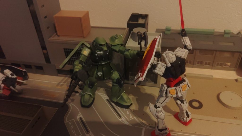 ガンダムにヒートホークで格闘戦を挑むザク。そして、盾でヒートホークを弾き飛ばしビームサーベルを振り降ろそうとするガンダム