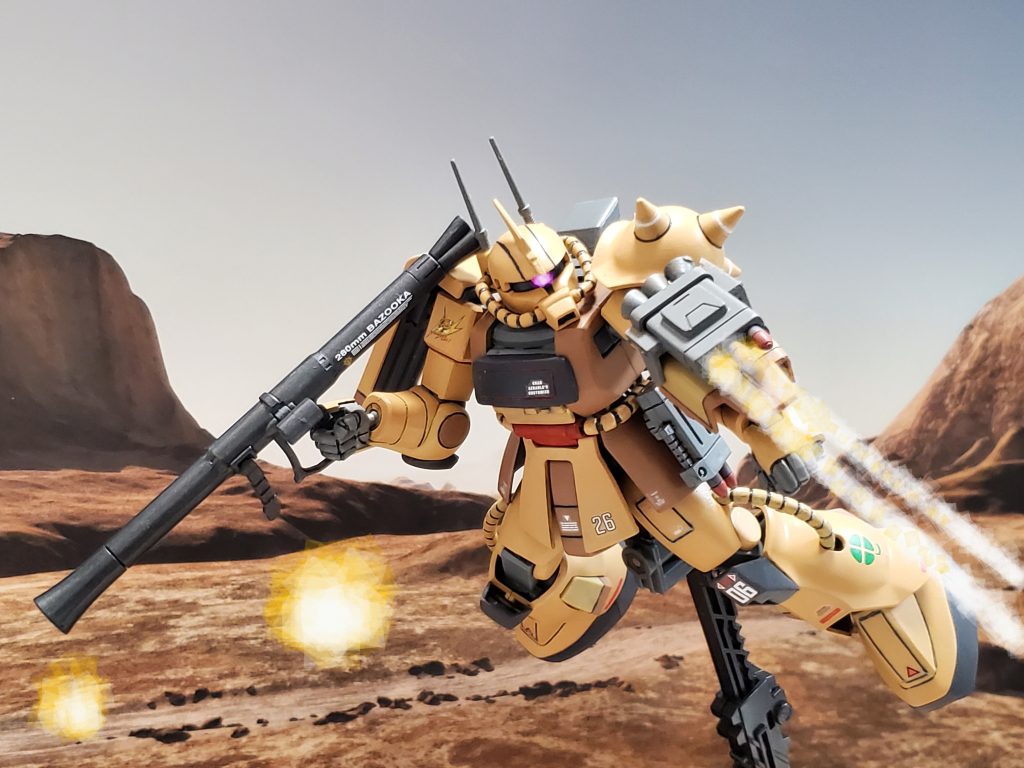 ベースキャンプ地に到着したグリンウッド少佐は、連邦部隊の掃討戦に入る😊🎶左腕に装着された3連ミサイルポッドを放ち敵機を排除👍✨戦闘の継続時間を得るために武装も充実しているザク デザートタイプ❕右腰部にはSA-712クラッカーポッド、左腰部には2連ミサイルポッドを装備😎