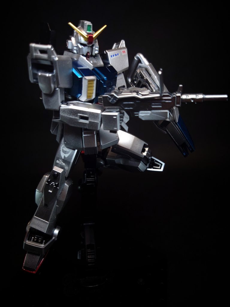 100ミリマシンガン型式番号：YHI YF-MG100[20] / NF GMG-Type.37/100mm[13]連邦MSの標準的な兵装[13]。ヤシマ重工により可搬型兵器構想に基づき開発された実体弾兵器で、MS自体に分解を行わせてコンテナに搭載し運搬することが可能[20]。劇中序盤から終盤まで陸戦型ガンダムの主武装として活躍した。標準的なボックス型マガジンの総弾数は48発で[20]、予備マガジンは腰部に装着することができる。小型で取り回しが良い上に陸戦型ザクIIの胴体を貫通する威力がある[25]。非常に信頼性が高いとされる一方、給弾までの複雑な機構が結果的に信頼性の低下を招いたと記載した資料もある[20]。劇中では多数のザクIIを撃破している。航空機にも有効であり、カレン・ジョシュワ機は第3話で戦闘ヘリを、第4話でドップを撃墜している。同話ではシロー機も本銃でノリス・パッカード大佐操縦のドップに損傷を負わせている。ジムや陸戦型ジムも装備しており[26]、映像作品の他にも『機動戦士ガンダム外伝 THE BLUE DESTINY』でのブルーディスティニー1号機や、『機動戦士ガンダム外伝 コロニーの落ちた地で…』でのホワイト・ディンゴ隊に配備されるジム、ガンキャノン量産型、ジム・スナイパーIIが装備している。