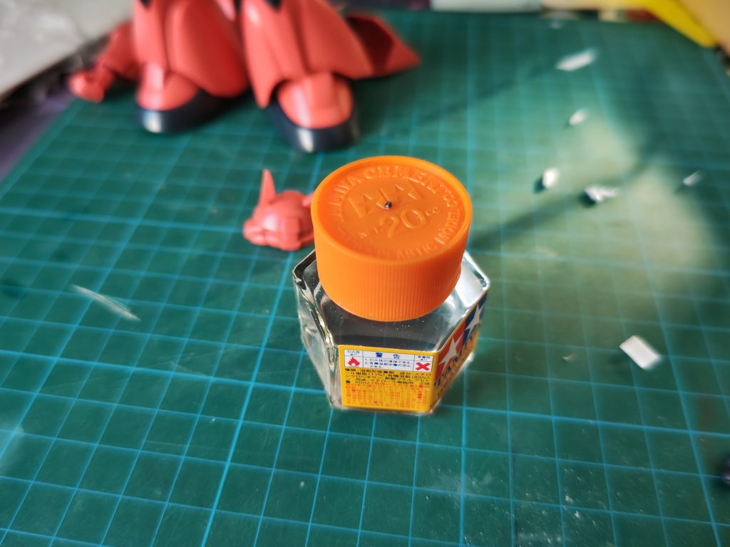 首関節の加工。ランナーを極小に切ったものを頭部側のピン接続用穴に放りこむだけです。サイズ比較の為に接着剤の瓶の上に置いてますが接着は不要。ピンが引っかかって奥まで入らなくなった分、首が延長されます。