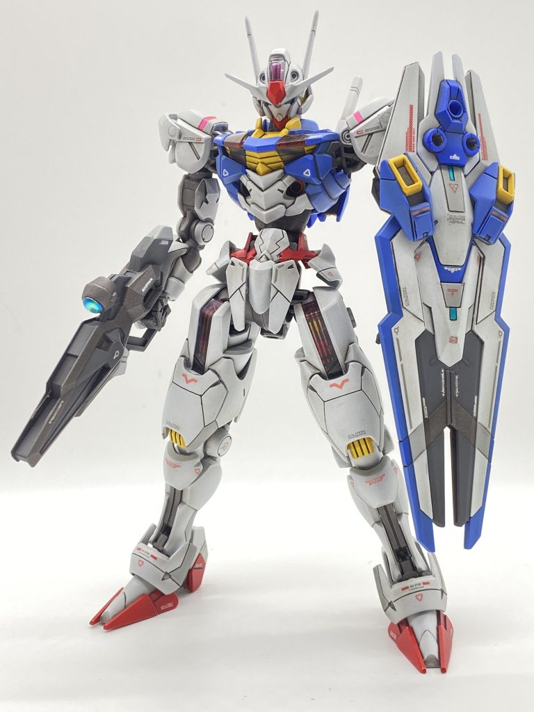 水星の魔女シリーズは、機体用の塗料も発売していますので、全塗装で製作しました。やったこととして、挙げてみると・アンテナのシャープ化・首のフロント側、両腕の付け根の胴体側のパーツの削り込みによる顎引き角、腕の前後角度の小拡張・肩アーマー上部の腕付け根側、膝パッド上部内側、エスカッシャン(盾)一部に段モールド・ウエスト部、プラ板にて2.4ミリ延長・脚の付け根パーツの左右入れ替え・脚部分の合わせ目消しによる、後ハメ組み・足部のプラ板貼り、エスカッシャン一部にパーツ貼りによるディテールアップ・各所、合わせ目消しと筋彫り・見えそうな足部肉抜き箇所のパテ埋め・エナメルのブラックを使用しての墨入れなどになります。