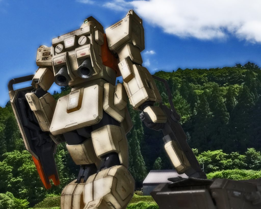 この補給部隊は独自のMSがあり資機材運搬以外に護衛としてMSを運用している。通常MSは補給部隊に配備されないが、それがあるという事はそれだけこの隊の重要性が覗える。部隊は密林を抜け拓けた場所に出ると、前には小さな村とその3倍位の畑が見えた。どうやら目的地はそこのようだ。「あの村で何をするんです?」「お若いの、百聞は一見にしかずじゃ。聞くのも良いが自身の眼でしっかり見極めるんじゃな」焦らすニッカードにネスカは少し不満げな表情をした。