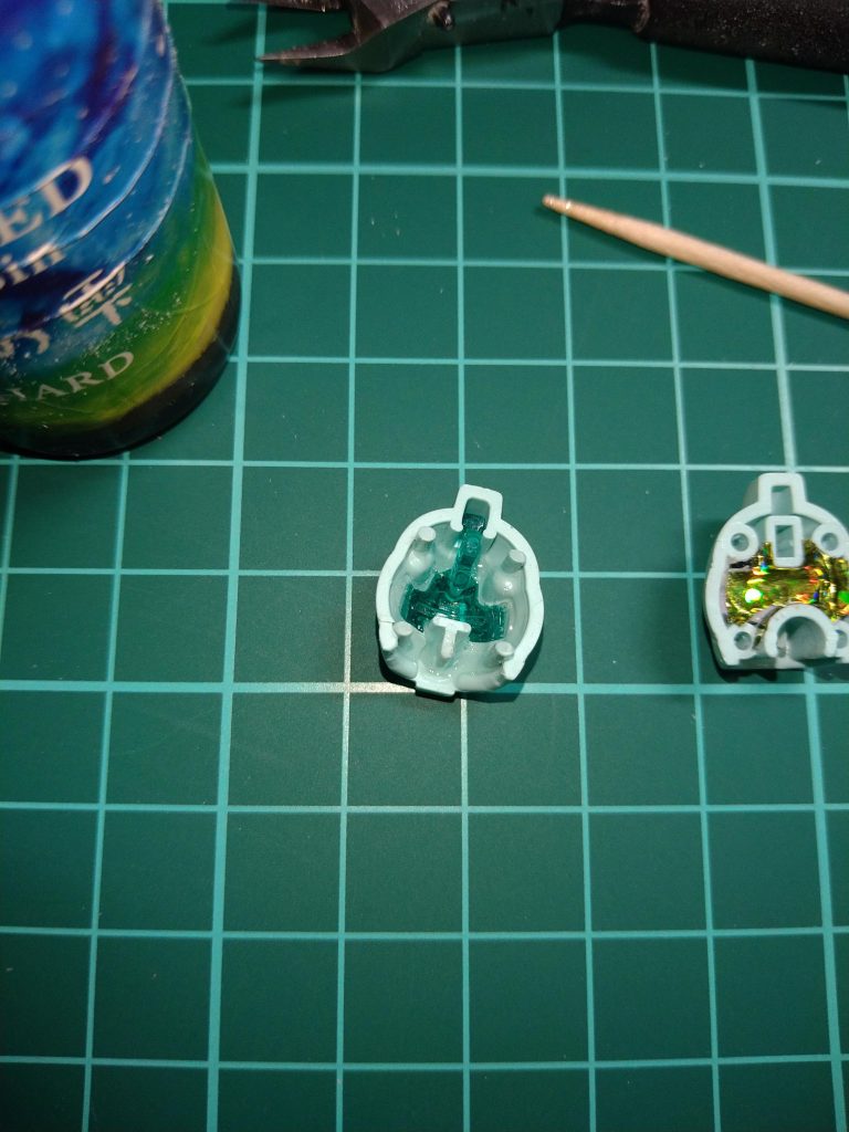 〘頭部〙[後ハメ加工]の製作でございます！😚先ず〘頭部前パーツ〙に〘ゴーグルクリアパーツ〙をはめ込み、ゴーグルの《周り》を裏からレジンで固めます！😚レジンが固まったら❲メインカメラ❳と❲ゴーグル❳をつなぐ部分をニッパーなどで切断！😆まずメインカメラを普通に取り出し…この時…妖怪パーツ隠しには十分注意！😠次に爪楊枝など、パーツを傷つけない道具で裏側から外に❲ゴーグル部分❳を押し出します！…この時レジンが多すぎてなかなか外れなくてけっこう力を使いました…😅…レジンは多すぎず…少なすぎず…😚大ざっぱに…てきとうに…😋その後、外したゴーグルパーツの気になる《点》をミニルータで削り、その後ペーパー……😐大ざっぱに６００番…適当に８００番………で１０００番のヤスリ途中で飽きて終了…😁私、いつもそうなのですが、クリアパーツやクリアのプラバン等についた傷などは特別大きく深い傷以外〘クリアトップコート〙吹けば何とかなると思っております！😚今回のジャンク品ジムも、新品以上の透明度になりました！🤗切り取ったメインカメラも元の位置に外側から差し込めるように、そして差し込んだ後〘ポロッ〙と抜け落ちないようにほんの少しだけ《きつめ》に成形