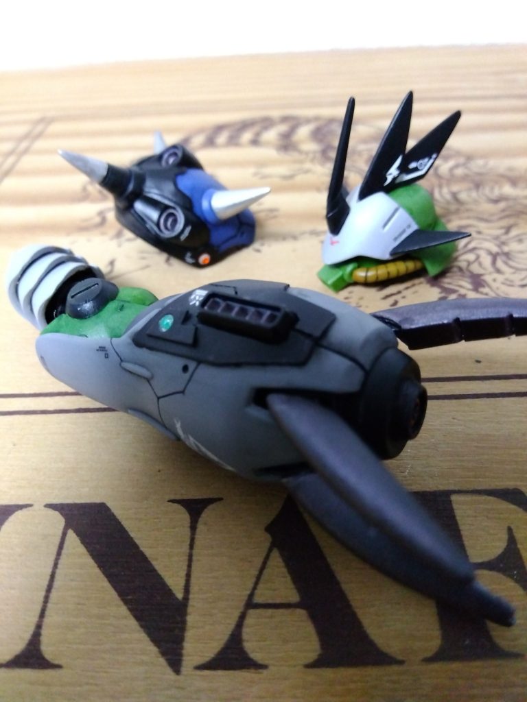 追加パーツ①頭部パーツはもうひとつの頭フリッツヘルムにジャンクとプラ板で作成。ここのデザインが最後まで決まらず一番の難所に(笑)モチーフはとあるモンスターをハントする戦士が竜の王様の素材で作った兜からwケンプ肩アーマーは真ん中のスラスターのみ切り離し後ハメ。先端以外のスパイクはぱんきちさんから教わったプラ棒を鉛筆削りでやる方法で作成!ずれたり穴空いたりで少し手こずりましたが、なんとか完成😅ぱんきちさんありがとうございました! ズゴックEの腕は突起部を私の定番改修ビルダーズパーツのスラスターに置き換え。その周りをプラ板でディテールアップ。銃口にはプラパイプで発射口を作成